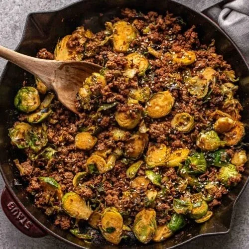 Beef Stir-Fry with Brussels sprouts on a plate garnished with sesame seeds