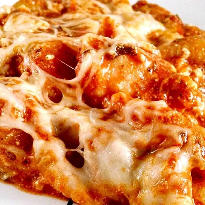 Baked creamy chicken pasta in a casserole dish topped with cheese