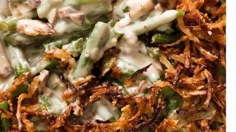 Creamy green bean casserole topped with crispy fried onions in a baking dish