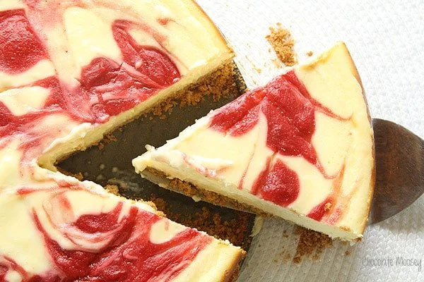 Creamy strawberry swirl cheesecake topped with fresh strawberries