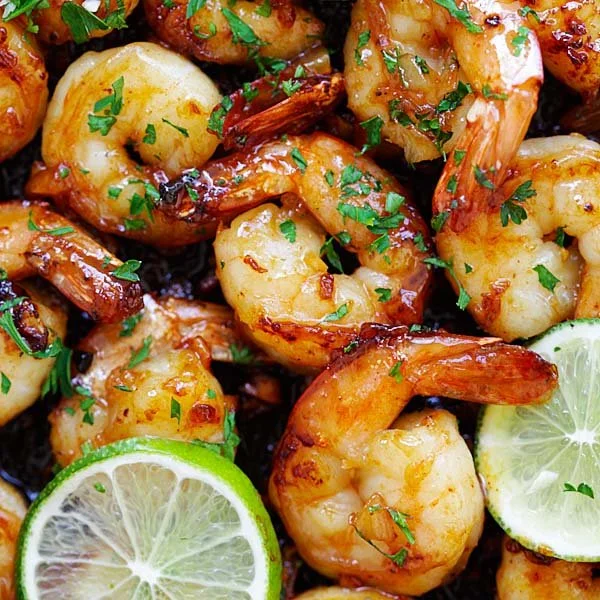 Delicious Garlic Honey Lime Shrimp served on a plate with fresh lime wedges.
