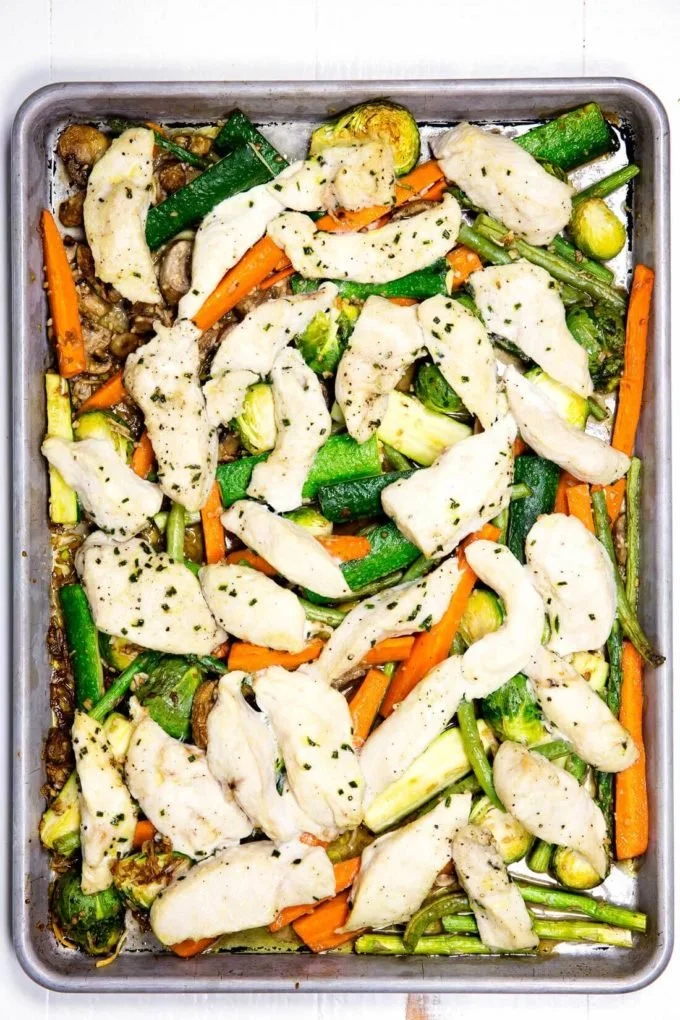 Sheetpan Garlic Chicken with colorful roasted vegetables on a baking tray.