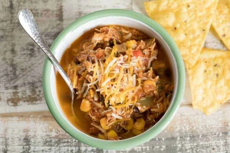 Bowl of spicy pressure cooker chicken soup with vegetables and herbs.