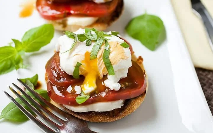 Delicious Tomato Mozzarella Sandwich served with fresh basil and a drizzle of olive oil