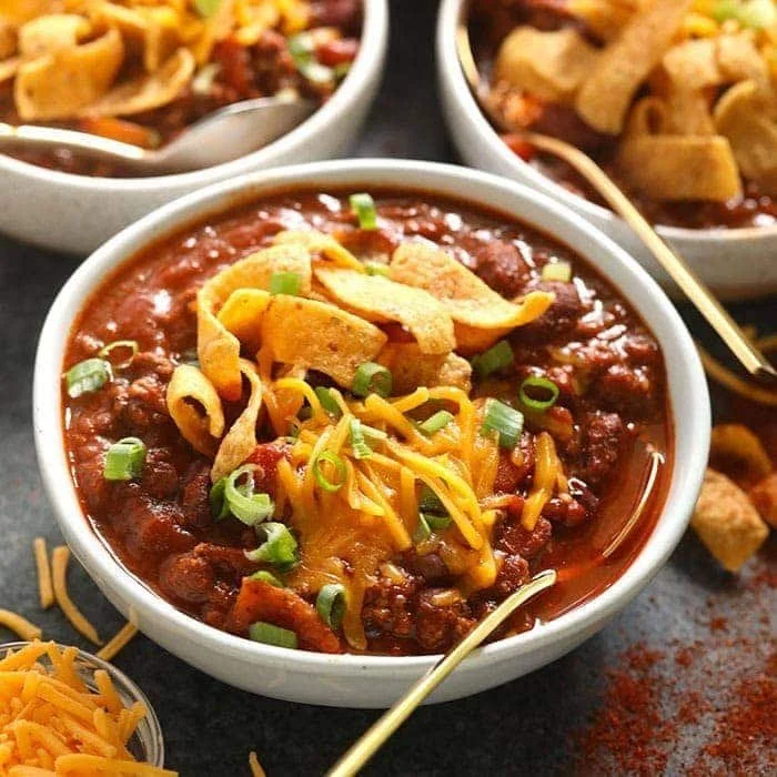 Bowl of ultimate chili recipe topped with cheese and cilantro